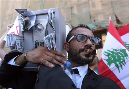 A Lebanese anti-government protester acts the role of a Lebanese politician during a demonstration against the trash crisis and government corruption, in downtown Beirut, Lebanon, Aug. 29, 2015. (AP Photo/Bilal Hussein) 