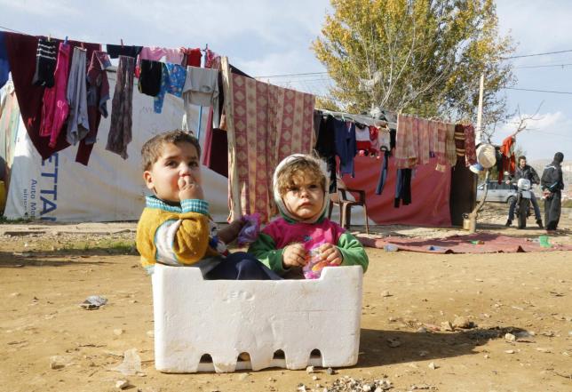 Syrian refugee children sit in a box at a makeshift settlement in Qab Elias in the Bekaa | Source: REUTERS/Mohamed Azakir